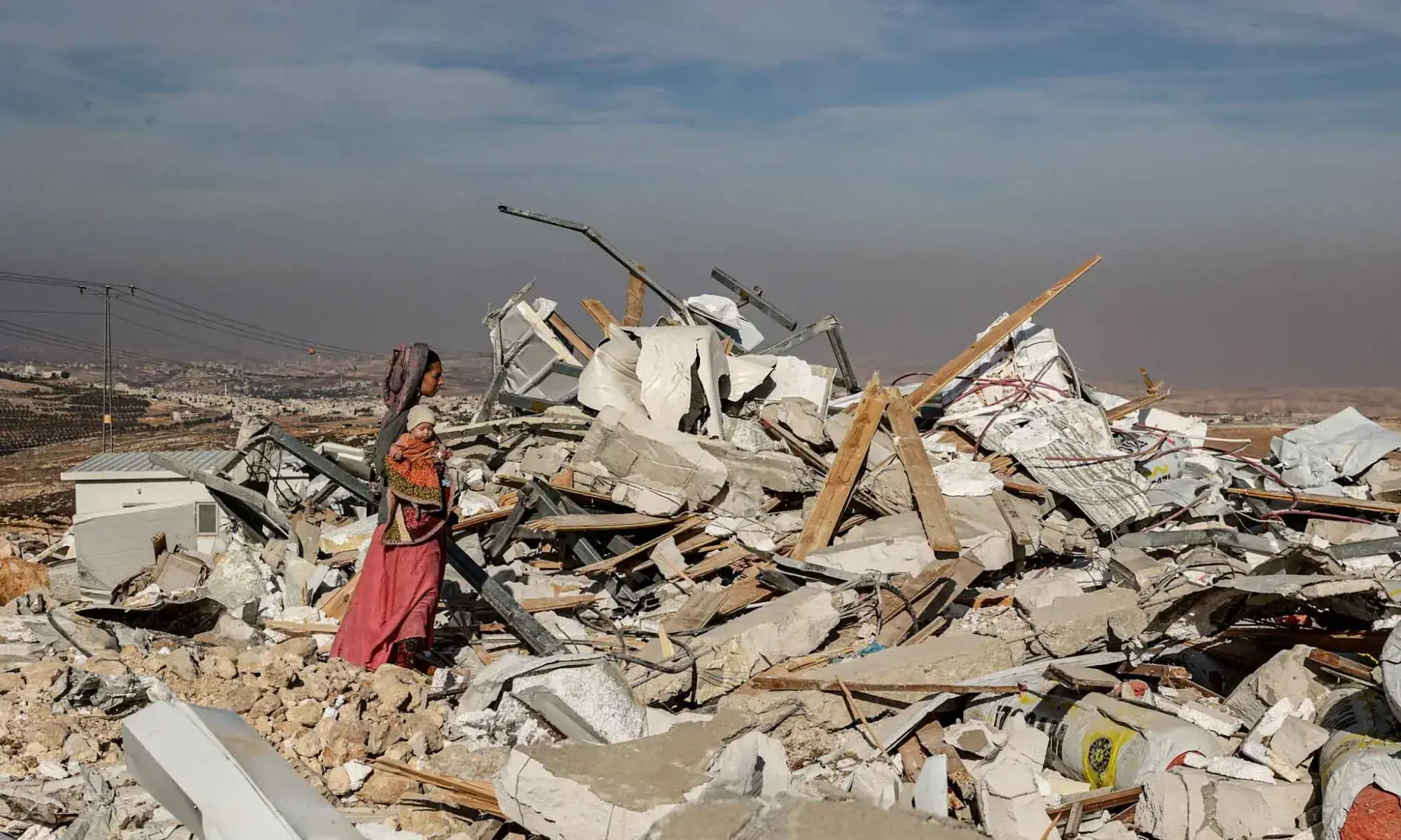 A woman holds her baby as Tzur Misgavi, an unauthorised Israeli settler outpost, is dismantled by Israeli security forces, in the Israeli-occupied West Bank on November 17. — Reuters A woman holds her baby as Tzur Misgavi, an unauthorised Israeli settler outpost, is dismantled by Israeli security forces, in the Israeli-occupied West Bank on November 17. — Reuters