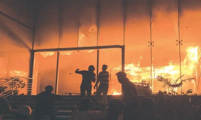 MEMBERS of a mob gather at the entrance to the The Daily Star office building after it was set alight, amidst protests following the death of Sharif Osman Hadi, a prominent student leader of the July uprising.&mdash;Reuters/ File