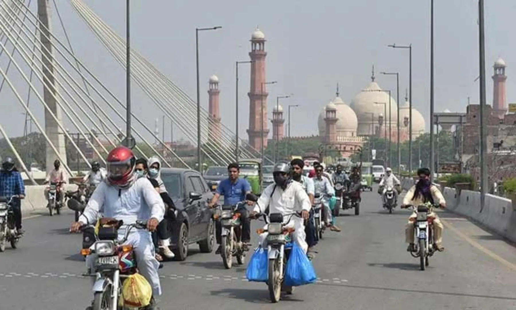 Commuters make their way along a street in Lahore. &mdash; AFP/File