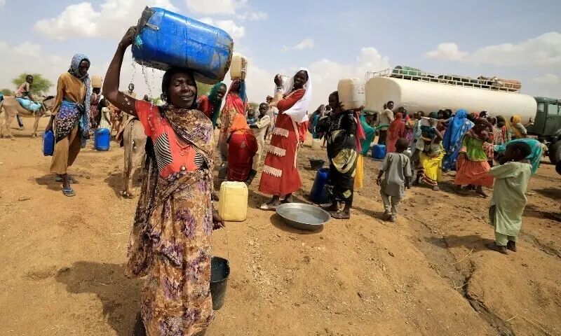 A Sudanese refugee woman, who fled the violence in Sudan&rsquo;s Darfur region, carries a jerrycan of water as she walks to her makeshift shelter near the border between Sudan and Chad in Koufroun, Chad, May 10, 2023. &mdash; Reuters/File