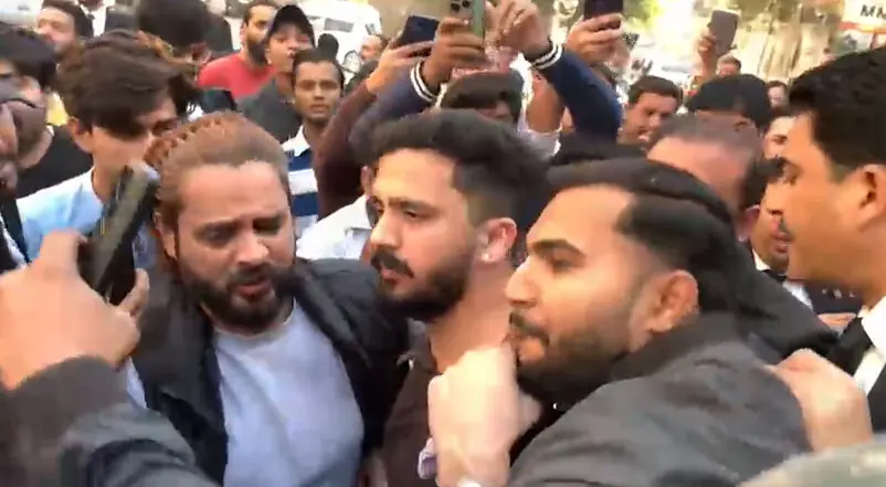Content creators Rajab Butt and Nadeem Mubarak, also known as Nani Wala, surrounded by a crowd at the Karachi sessions court central on December 29. &mdash; Screengrab from video provided by author