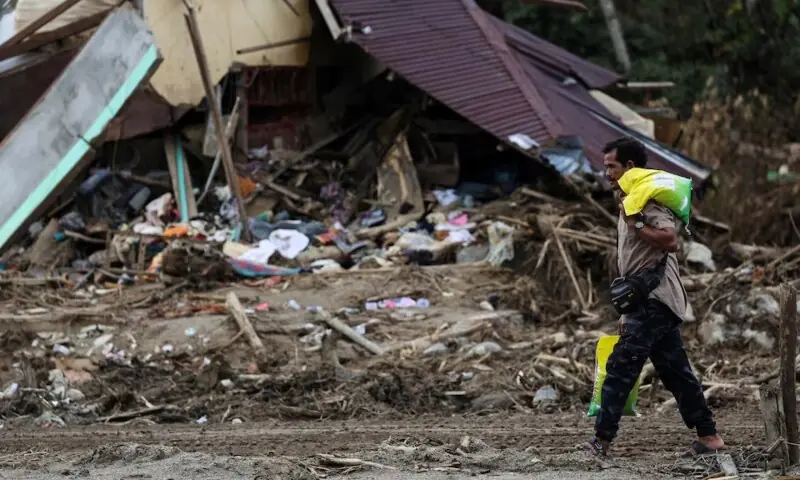 A local resident carries relief supplies following a deadly flash flood in Batang Toru, South Tapanuli, North Sumatra province, Indonesia on December 7. &mdash;Reuters/ File