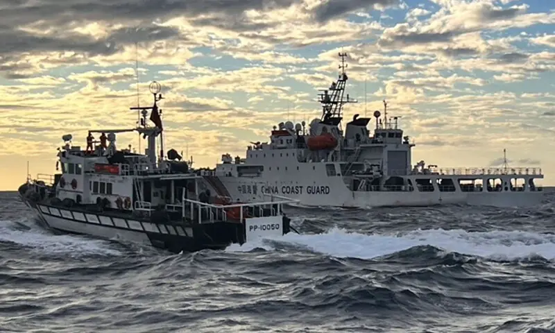 This handout photo, taken on December 29 and released on December by the Taiwanese Coast Guard, shows a Taiwanese coast guard ship (L) sending warnings to a Chinese coast guard ship in the waters off Taiwan’s Cape Fugui. — AFP