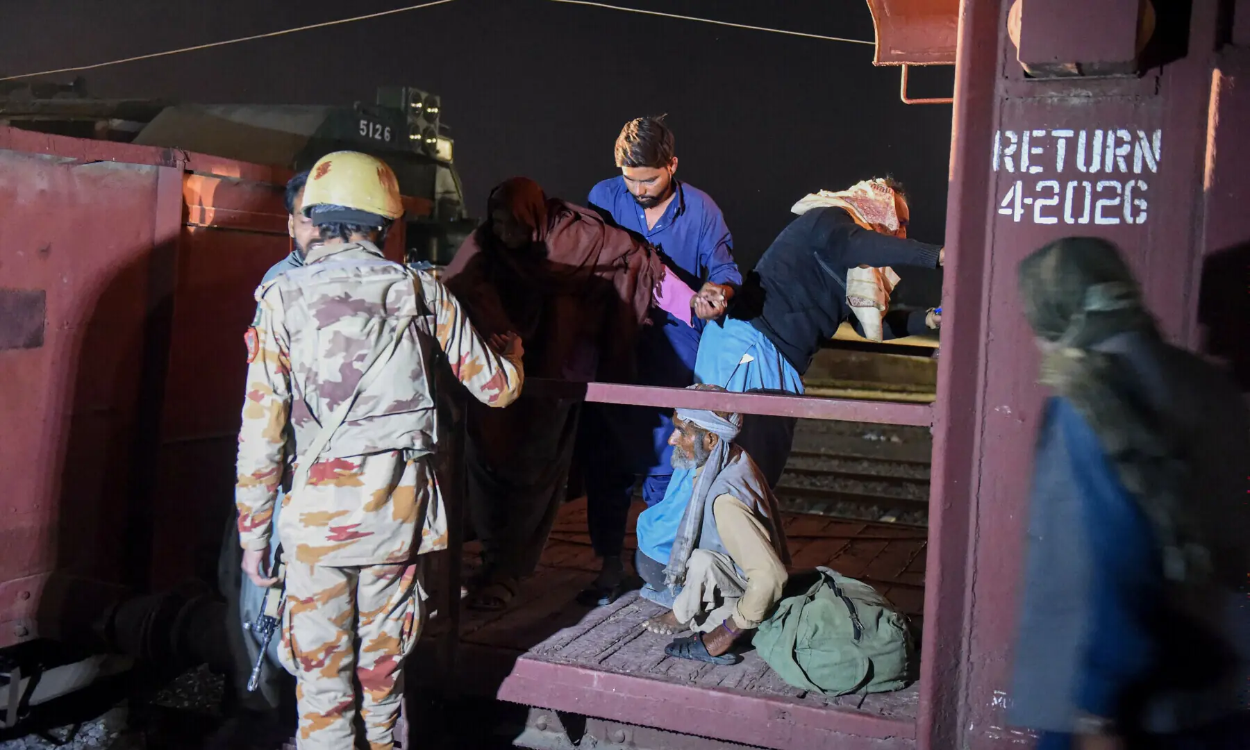 A soldier (L) works to evacuate freed train passengers at the Mach railway station, which has been turned into a makeshift hospital, after Pakistani security forces freed nearly 80 passengers following a security operation against armed militants who ambushed the train in the remote mountainous area, in Mach on March 11. — AFP/File