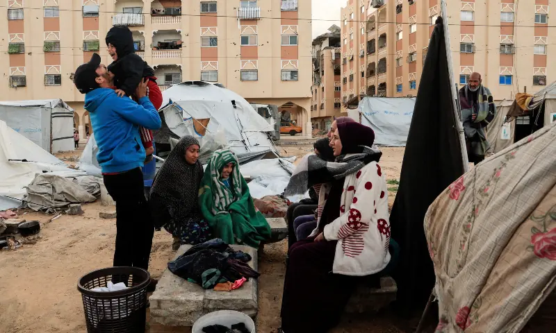 Displaced Palestinians take shelter in a tent camp, amid cold weather, in Khan Younis, southern Gaza Strip on December 28, 2025. &mdash; Reuters