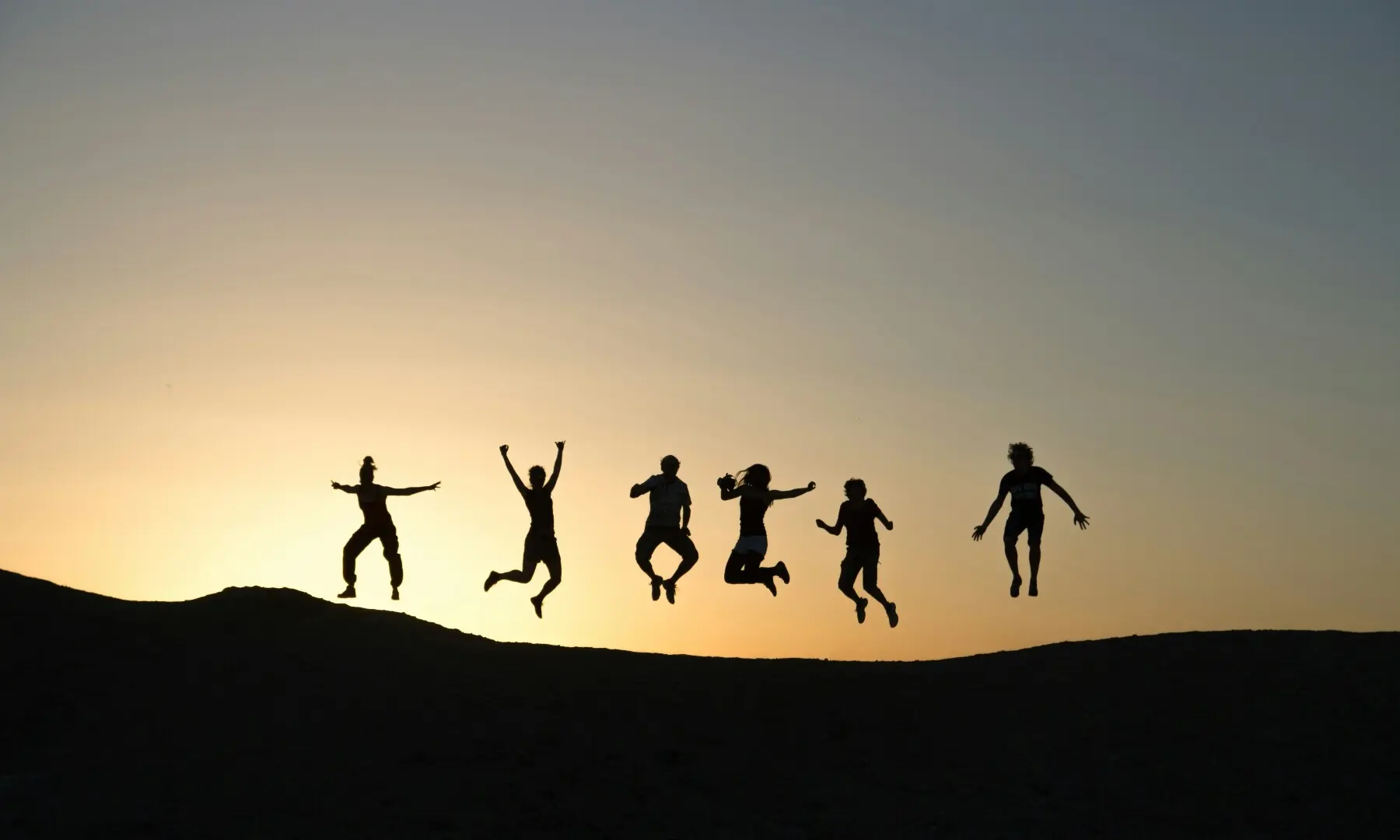 Image showing silhouettes of people jumping. &mdash;Timon Studler / Unsplash