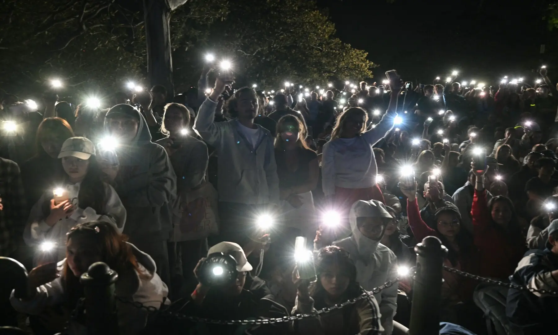 People turn on their mobile phones&rsquo; flashlights as they observe a minute&rsquo;s silence to reflect on the tragic Bondi Beach shooting attack before New Year&rsquo;s Eve midnight fireworks display in Sydney on December 31, 2025. &mdash; Saeed Khan / AFP