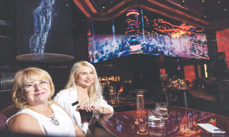 Customers react while seated inside Woohoo, an AI-powered restaurant in Dubai.&mdash;AFP