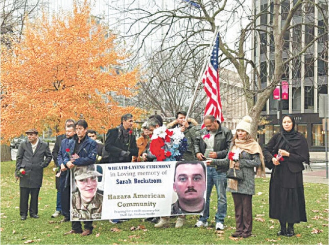 MEMBERS of the Hazara American Community hold a banner honouring the National Guard killed in the Washington attack.—Dawn