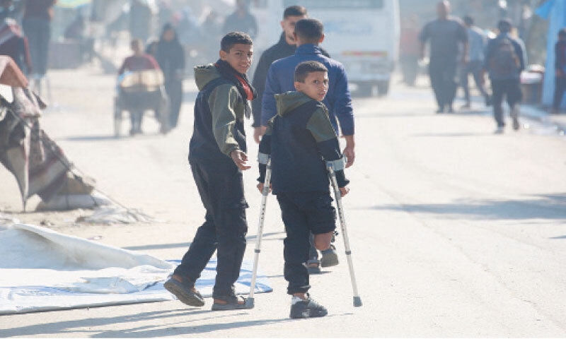 Nine-year-old Rateb Mahmoud Qaliq uses his crutches rather than his ill-fitting prosthetic leg, as he joins his friends at a school run by UNRWA in Deir al-Balah, central Gaza Strip. The school has become a shelter for displaced people in Gaza.&mdash;AFP