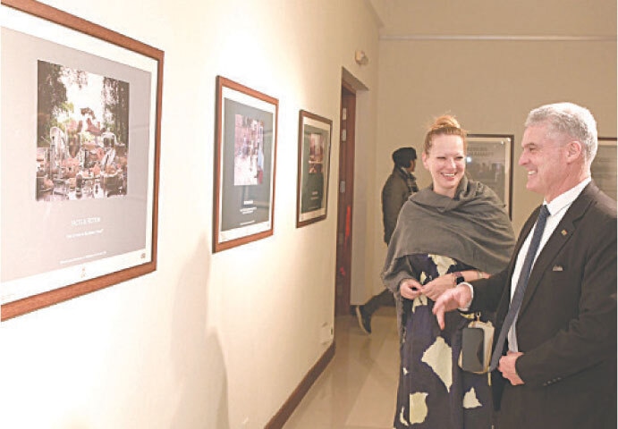 Visitors are all smiles as they look at photographs on display at an exhibition at the PNCA in Islamabad on Friday. &mdash; White Star