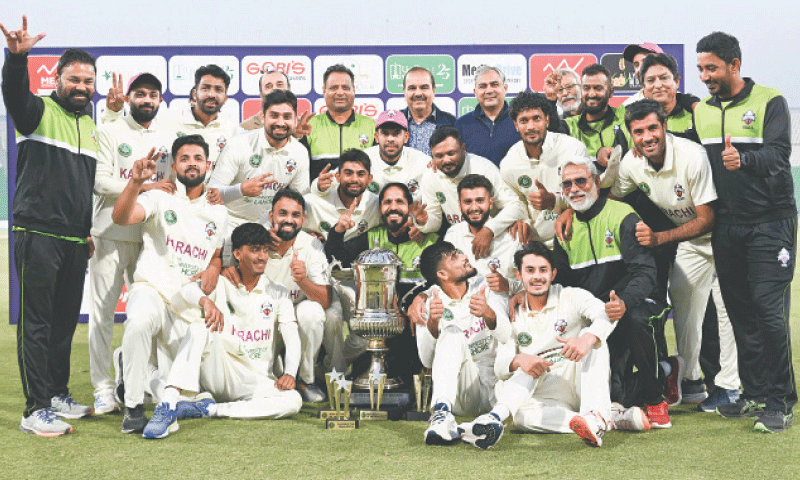 PLAYERS and officials of Karachi Blues celebrate with the trophy after their victory against Sialkot in the Quaid-e-Azam Trophy final at the Gaddafi Stadium on Friday.&mdash;Courtesy PCB