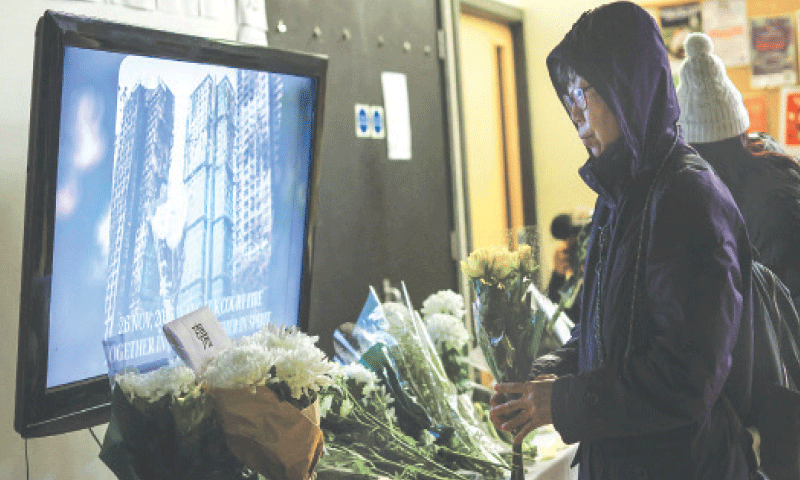 A person places flowers at an altar during a vigil for victims of last week’s Wang Fuk Court fire, which claimed 159 lives.—Reuters A person places flowers at an altar during a vigil for victims of last week’s Wang Fuk Court fire, which claimed 159 lives.—Reuters