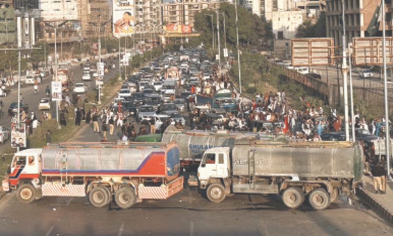 Sharea Faisal is blocked with heavy vehicles to prevent rally participants from entering Red Zone.—Shakil Adil / White Star Sharea Faisal is blocked with heavy vehicles to prevent rally participants from entering Red Zone.—Shakil Adil / White Star