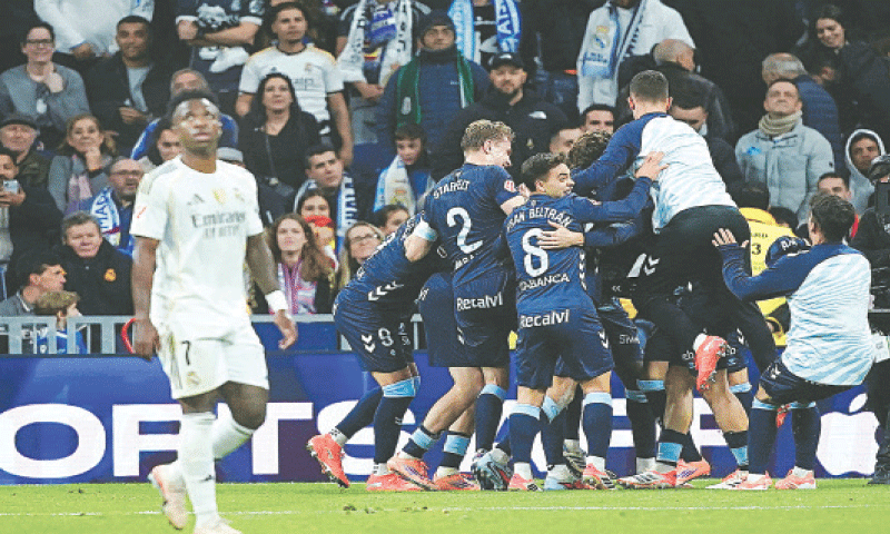 MADRID: Real Madrid’s Vinicius Jr reacts as Celta Vigo players celebrate after Williot Swedberg scored during the La Liga match at the Santiago Bernabeu.—Reuters MADRID: Real Madrid’s Vinicius Jr reacts as Celta Vigo players celebrate after Williot Swedberg scored during the La Liga match at the Santiago Bernabeu.—Reuters