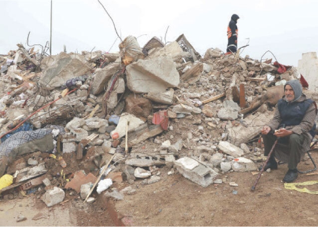 An elderly man sits next to the rubble of two collapsed buildings in the city&rsquo;s Al Massira area.&mdash;AFP