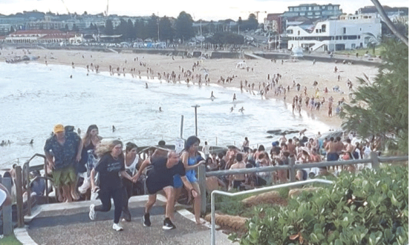 SYDNEY: This screen grab shows people fleeing Bondi Beach after gunmen opened fire during an event held to celebrate the Jewish holiday of Hanukkah.—AFP SYDNEY: This screen grab shows people fleeing Bondi Beach after gunmen opened fire during an event held to celebrate the Jewish holiday of Hanukkah.—AFP