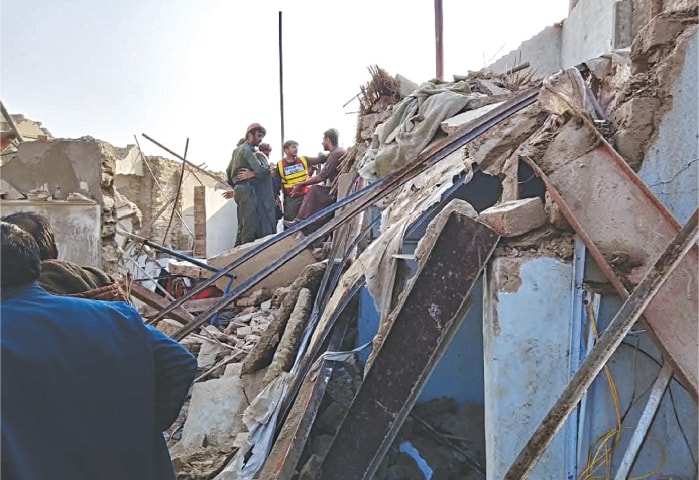 RESCUERS try to reach out to people trapped under the rubble of several collapsed houses in Larkana on Tuesday.&mdash;Dawn