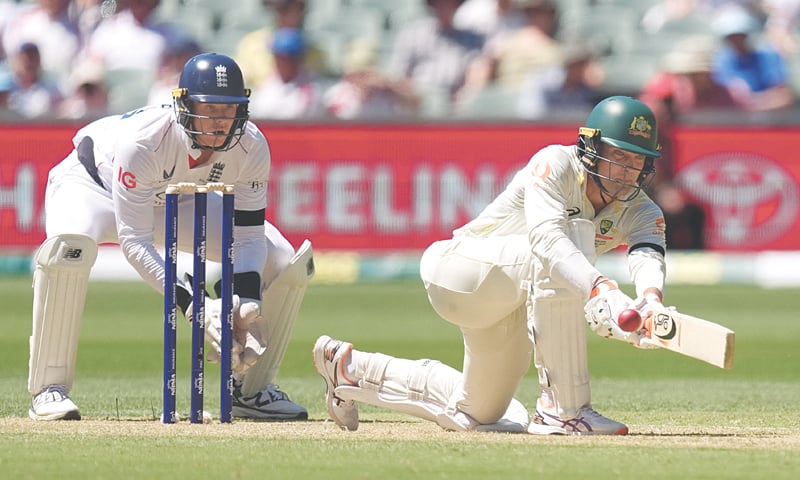 AUSTRALIAN batter Alex Carey sweeps as England wicket-keeper Jamie Smith looks on during the third Ashes Test at the Adelaide Oval on Wednesday.&mdash;Reuters