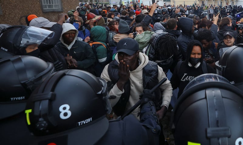 A PERSON looks on as people clash with police during the eviction of migrants from a former school in Badalona, Spain.—Reuters A PERSON looks on as people clash with police during the eviction of migrants from a former school in Badalona, Spain.—Reuters