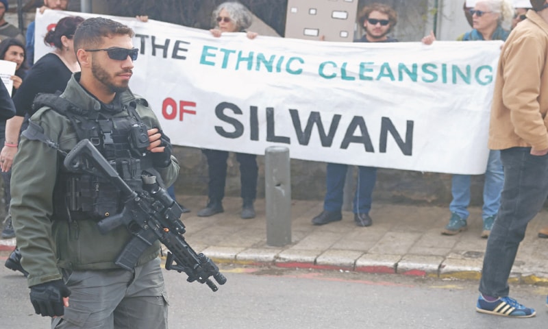 JERUSALEM: Israeli and foreign activists hold placards during a protest against Tel Aviv’s plans to demolish houses in Silwa, a predominantly Arab neighbourhood.—AFP JERUSALEM: Israeli and foreign activists hold placards during a protest against Tel Aviv’s plans to demolish houses in Silwa, a predominantly Arab neighbourhood.—AFP