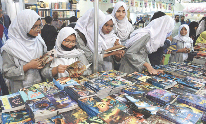 Schoolchildren browse through books at one of the stalls.—Online Schoolchildren browse through books at one of the stalls.—Online