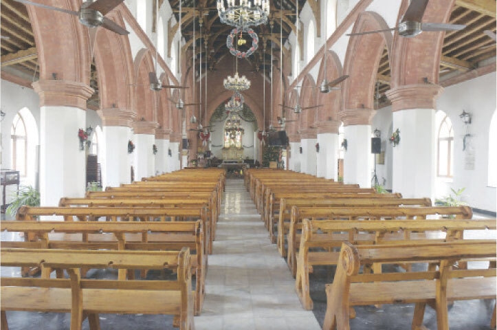 The main hall of the church features wooden benches to accommodate worshippers during prayers.