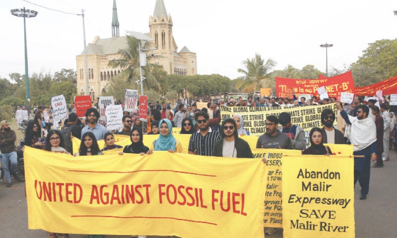 Participants of the march hold banners in the Frere Hall gardens. —Shakil Adil / White Star Participants of the march hold banners in the Frere Hall gardens. —Shakil Adil / White Star