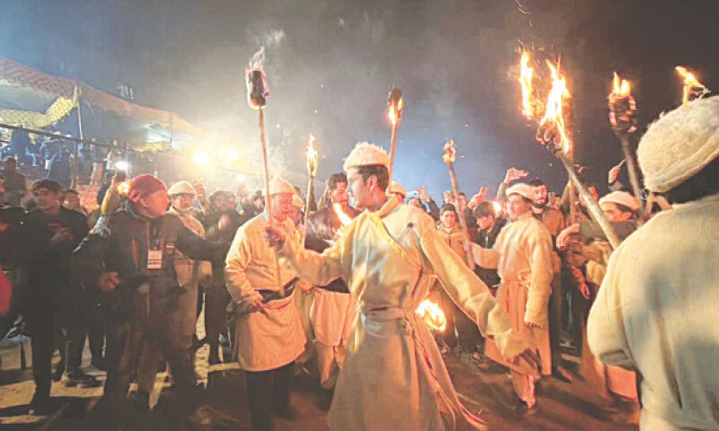 LOCALS in traditional attire carry flaming logs at the festival.&mdash;Dawn