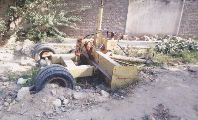 Land-levelling machinery worth millions of rupees rusts in the open. &mdash; Dawn