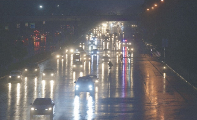Headlights of vehicles shimmer on the wet Faisal Avenue after Islamabad received rain on Tuesday. &mdash; White Star