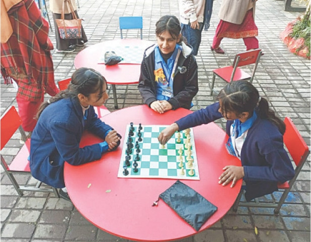 A Student makes a move during a chess game during the championship in Peshawar on Monday. — Dawn