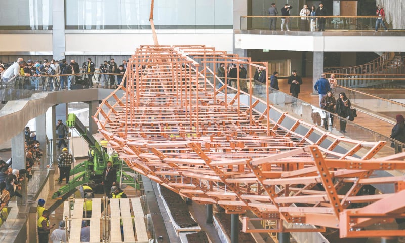 Museum employees install antique wooden planks from King Khufu&rsquo;s second boat onto a metal structure at the Grand Egyptian Museum in Giza.&mdash;AFP