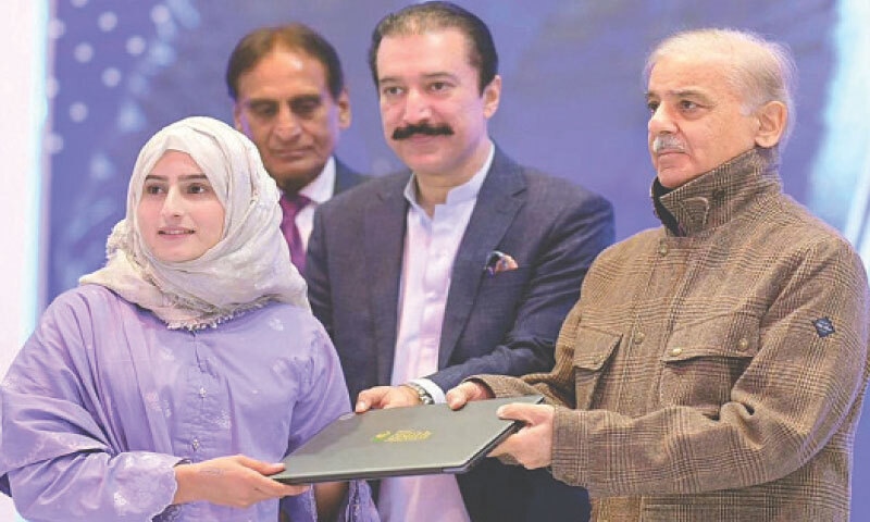 Prime Minister Shehbaz Sharif hands over a laptop to a student during a ceremony at the University of Azad Jammu
and Kashmir.—PPI Prime Minister Shehbaz Sharif hands over a laptop to a student during a ceremony at the University of Azad Jammu
and Kashmir.—PPI