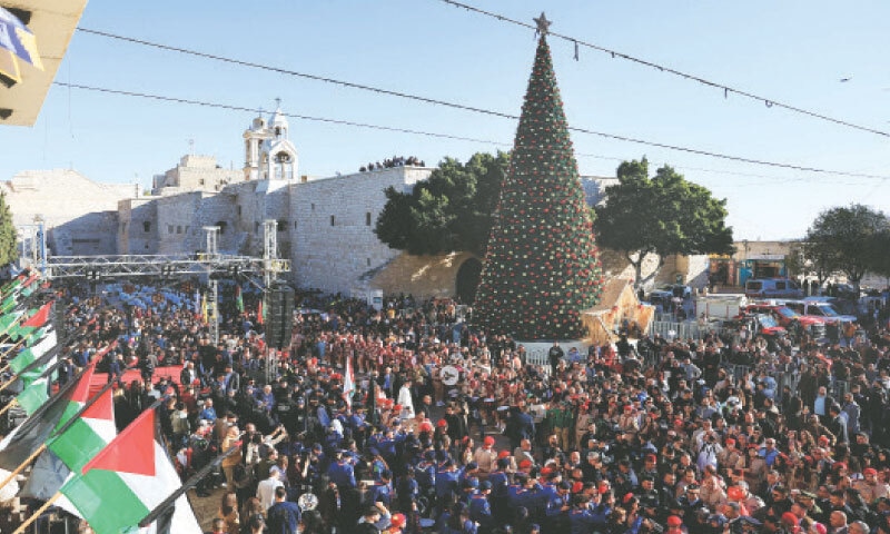 BETHLEHEM: Scouts and worshippers gather next to the tree at Manger Square, as the biblical birthplace of Jesus Christ witnessed the first festive Christmas since the war on Gaza broke out. Jerusalem&rsquo;s Latin Patriarch later led the traditional Midnight Mass at the Church of the Nativity.&mdash;Reuters