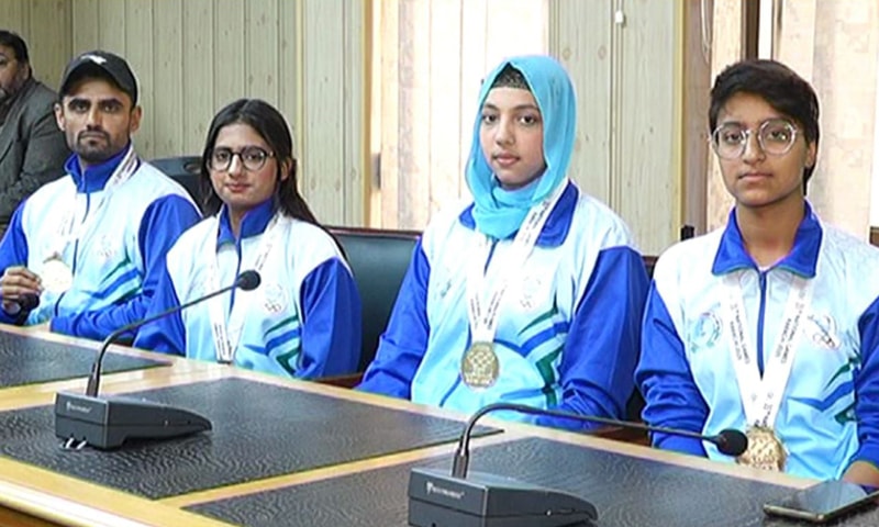 Four national games winners wearing medals and sports uniforms sitting at a conference table. — Dawn Four national games winners wearing medals and sports uniforms sitting at a conference table. — Dawn