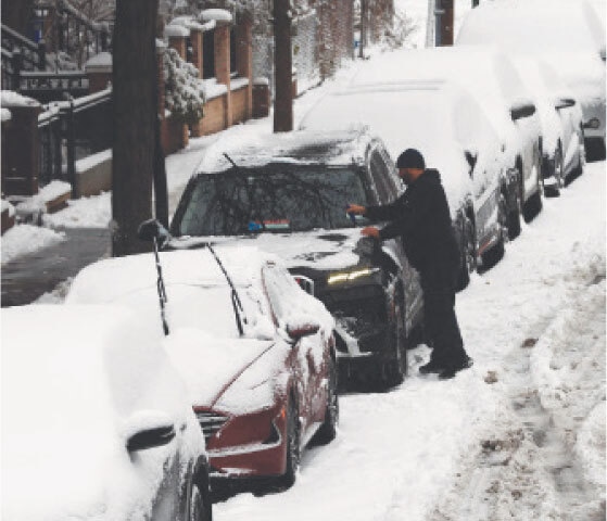 NEW YORK CITY: A man cleans off his car of snow in Brooklyn after an overnight storm on Saturday.—AFP