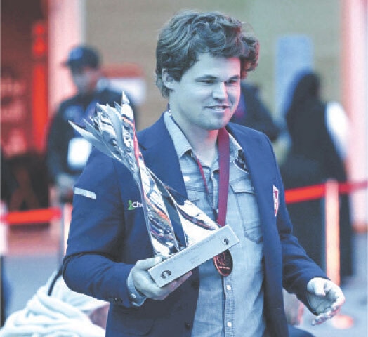 NORWAY&rsquo;S Magnus Carlsen holds the trophy after winning the blitz title during the FIDE World Rapid and Blitz Championship at the Sports and Events Complex of the Qatar University.&mdash;AFP