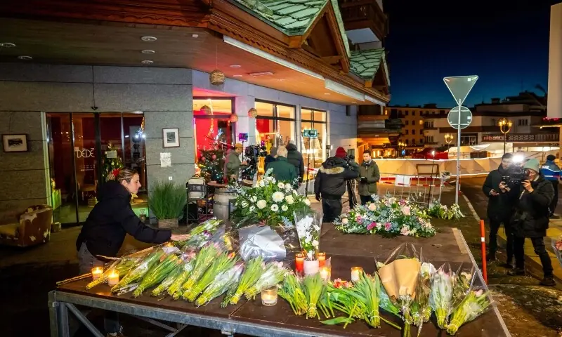 A woman lays flowers at the site where a fire ripped through a crowded bar in the Alpine ski resort town of Crans-Montana on January 1, 2026. &mdash;AFP
