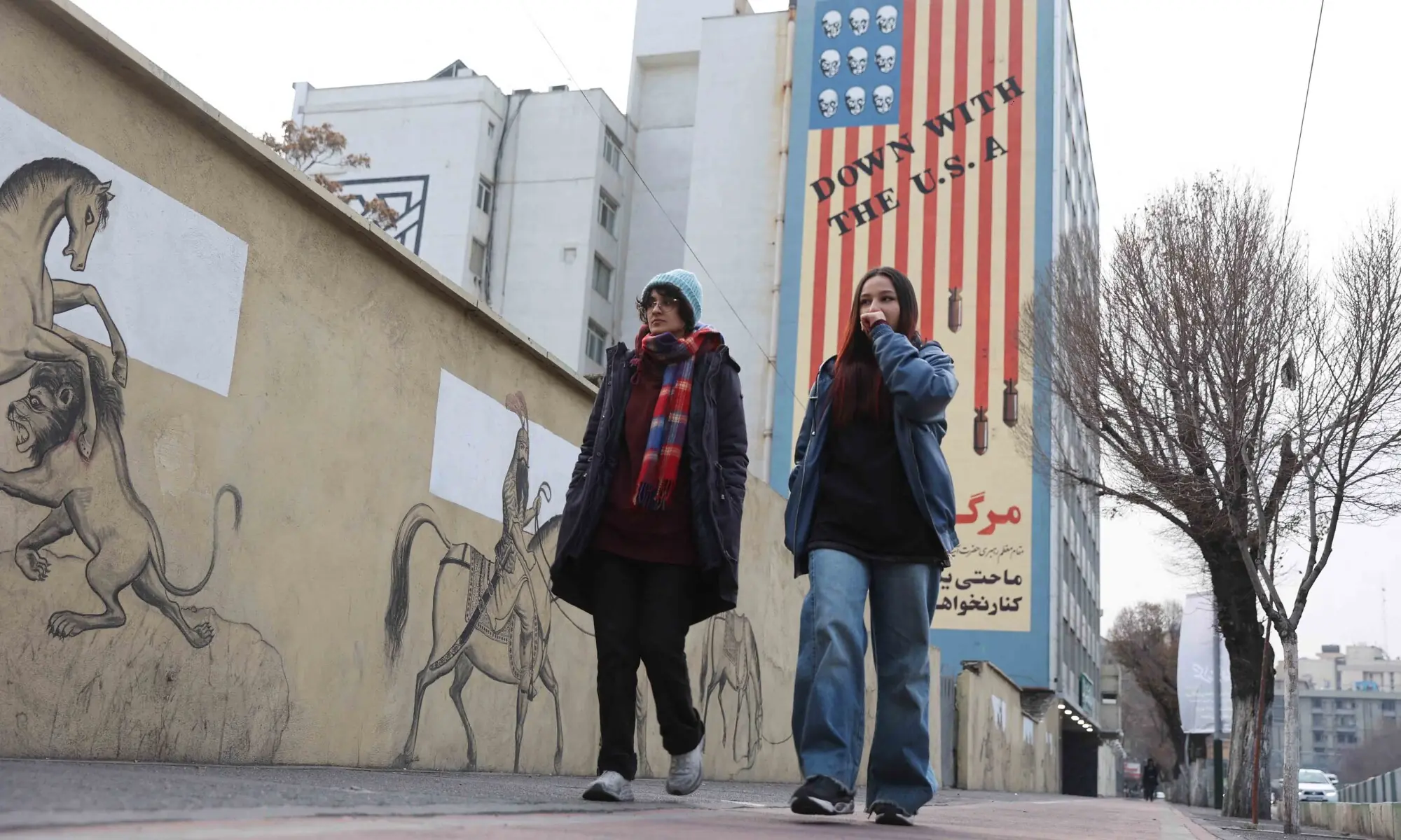 TEHRAN: Women walk next to an anti-US mural on a street. Protests have erupted across the country, triggered by the collapse of Iran&rsquo;s currency and economic woes.&mdash;Reuters