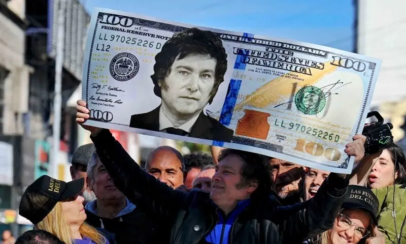 Argentine congressman and presidential candidate for the La Libertad Avanza Alliance, Javier Milei (C), holds a giant 100-dollar bill with his face painted on it during a campaign rally in San Martin, Buenos Aires province, Argentina, on September 25, 2023. — AFP Argentine congressman and presidential candidate for the La Libertad Avanza Alliance, Javier Milei (C), holds a giant 100-dollar bill with his face painted on it during a campaign rally in San Martin, Buenos Aires province, Argentina, on September 25, 2023. — AFP