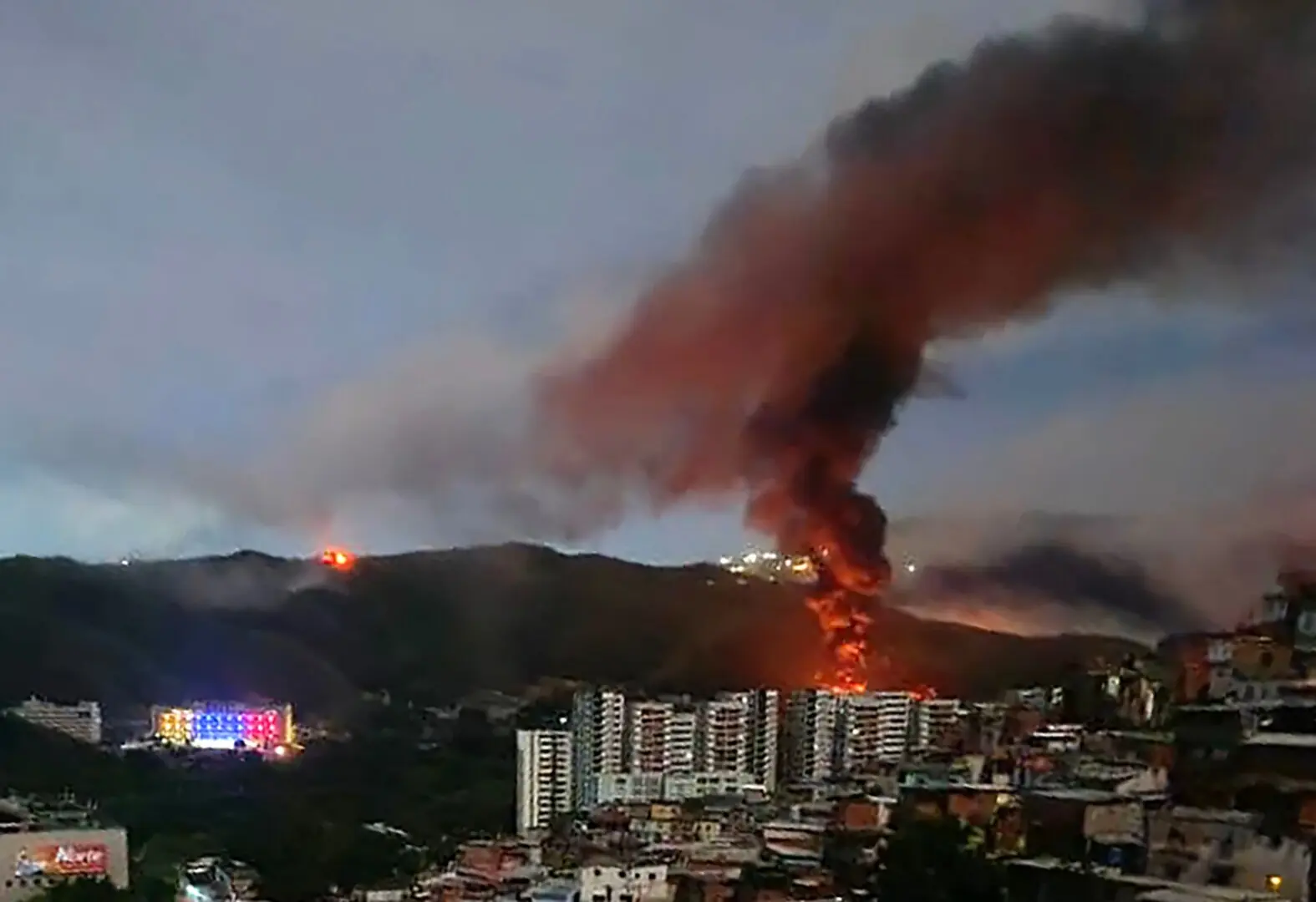 Fire at Fuerte Tiuna, Venezuela’s largest military complex, is seen from a distance after a series of explosions in Caracas on January 3, 2026. — AFP
