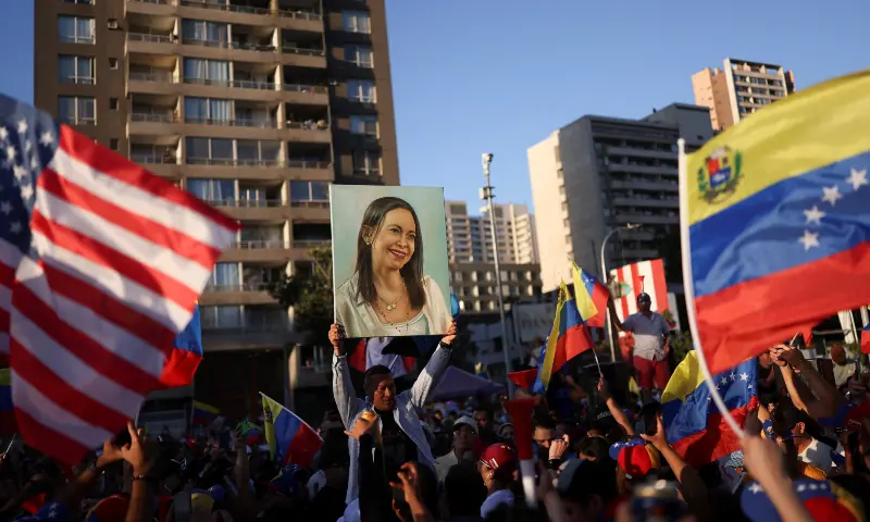 A person holds up an image depicting Venezuelan opposition leader Maria Corina Machado, as people celebrate after the US struck Venezuela and captured its President Nicolas Maduro and his wife Cilia Flores, in Santiago, Chile on January 3, 2026. &mdash; Reuters