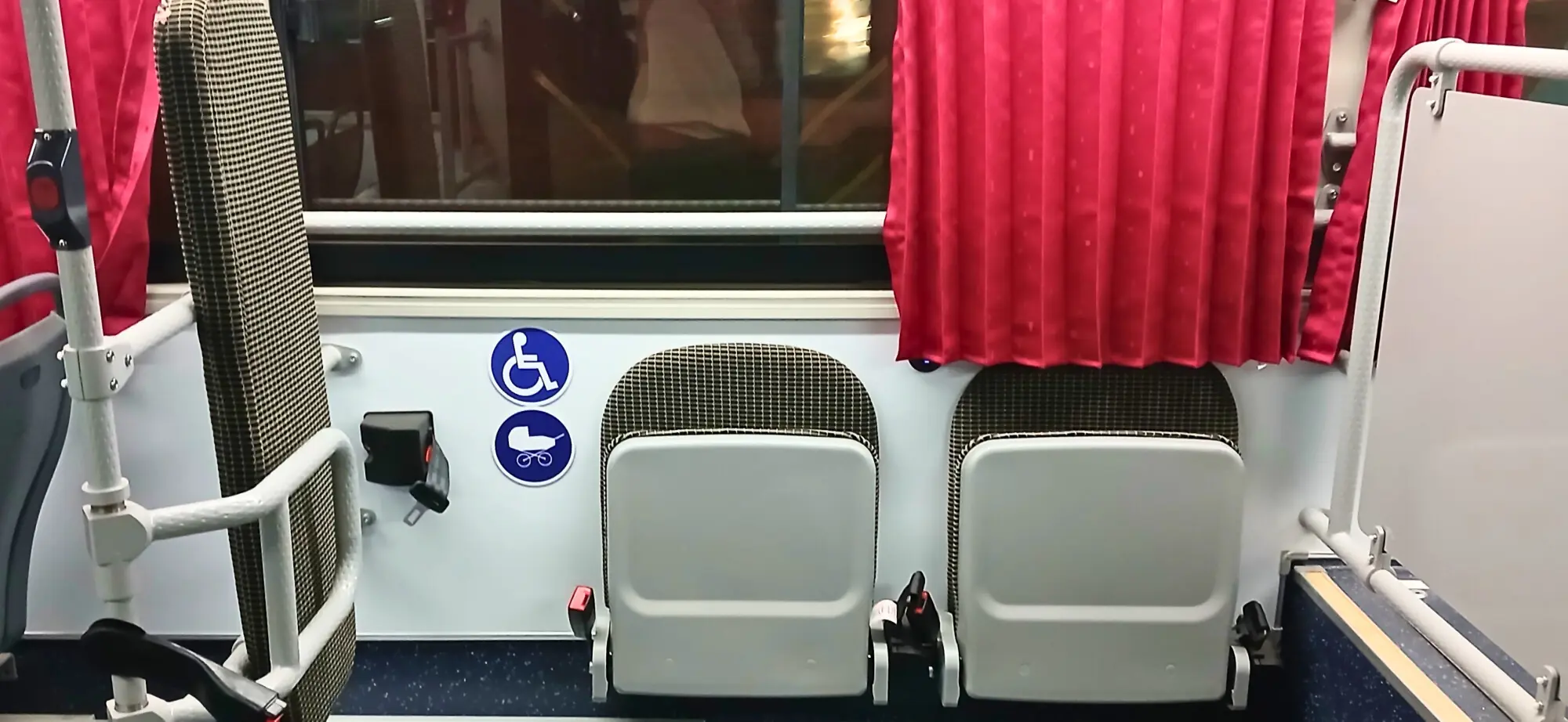 Designated seats for people with disabilities and a space to park strollers . — Photo by author