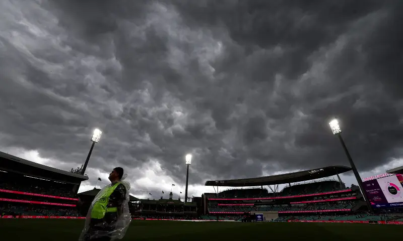 A security guard stands in the outfield as rain falls on day one of the fifth Ashes cricket Test match between Australia and England at the Sydney Cricket Ground (SCG) in Sydney on January 4, 2026. &mdash; AFP