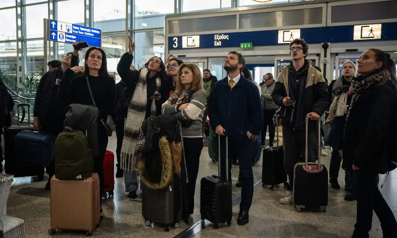 Passengers check screens for flight information as traffic is delayed or reported due to technical issues at a departure hall of Athens&rsquo; Eleftherios Venizelos international airport in Spata near Athens, on January 4, 2026. &mdash; AFP