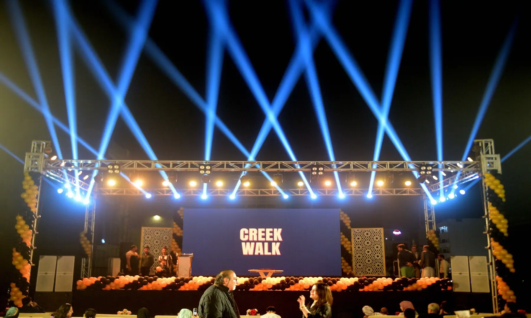 Blue lights illuminate the Creek Walk stage as people stroll past. Lights are installed across the food street to attract customers, who often pause to take in the sights and smells of the food. &mdash; Tahir Jamal/White Star