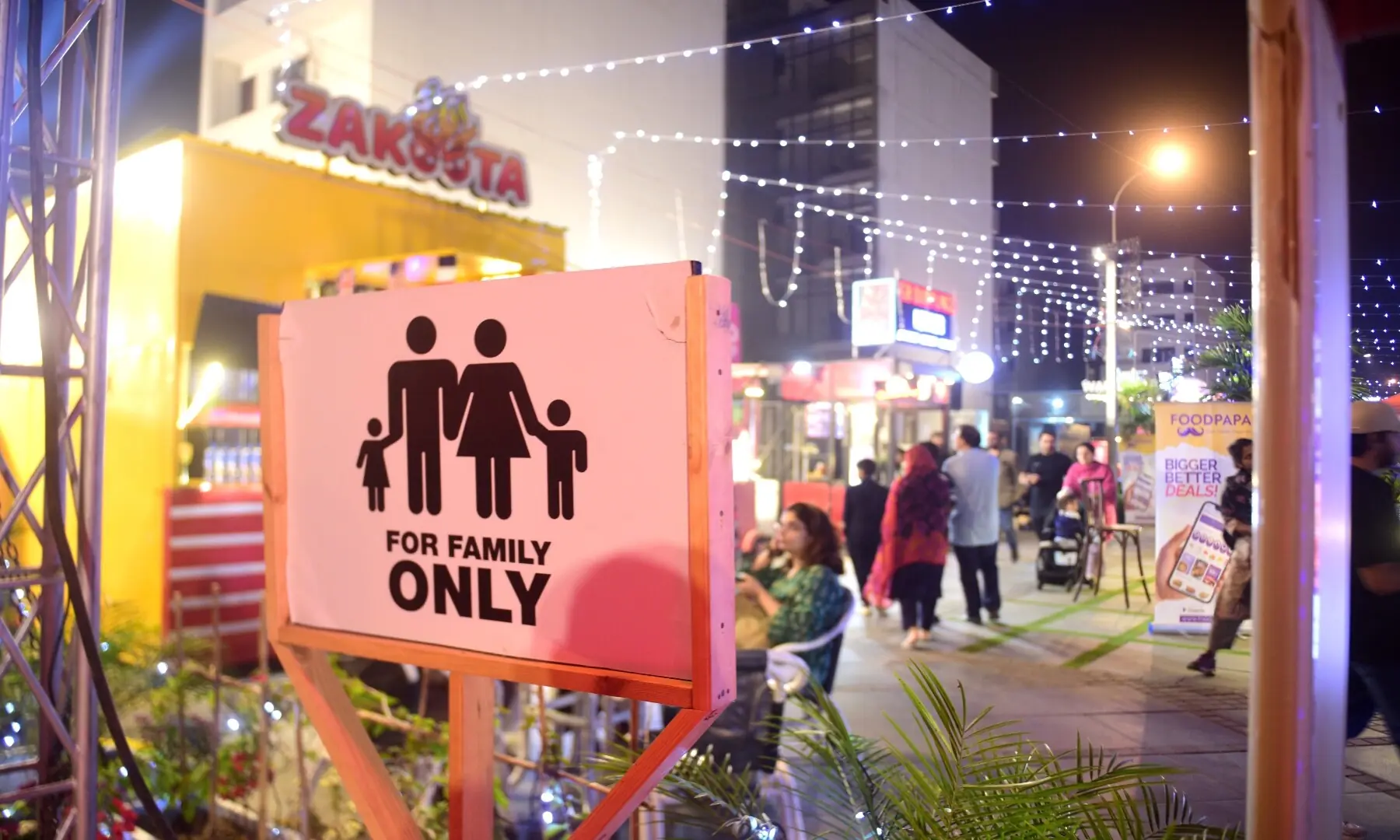 A sign reading &lsquo;For Family Only&rsquo; at new food street in Karachi&rsquo;s DHA, as people walk past food stalls and restaurants. &mdash; Tahir Jamal/White Star