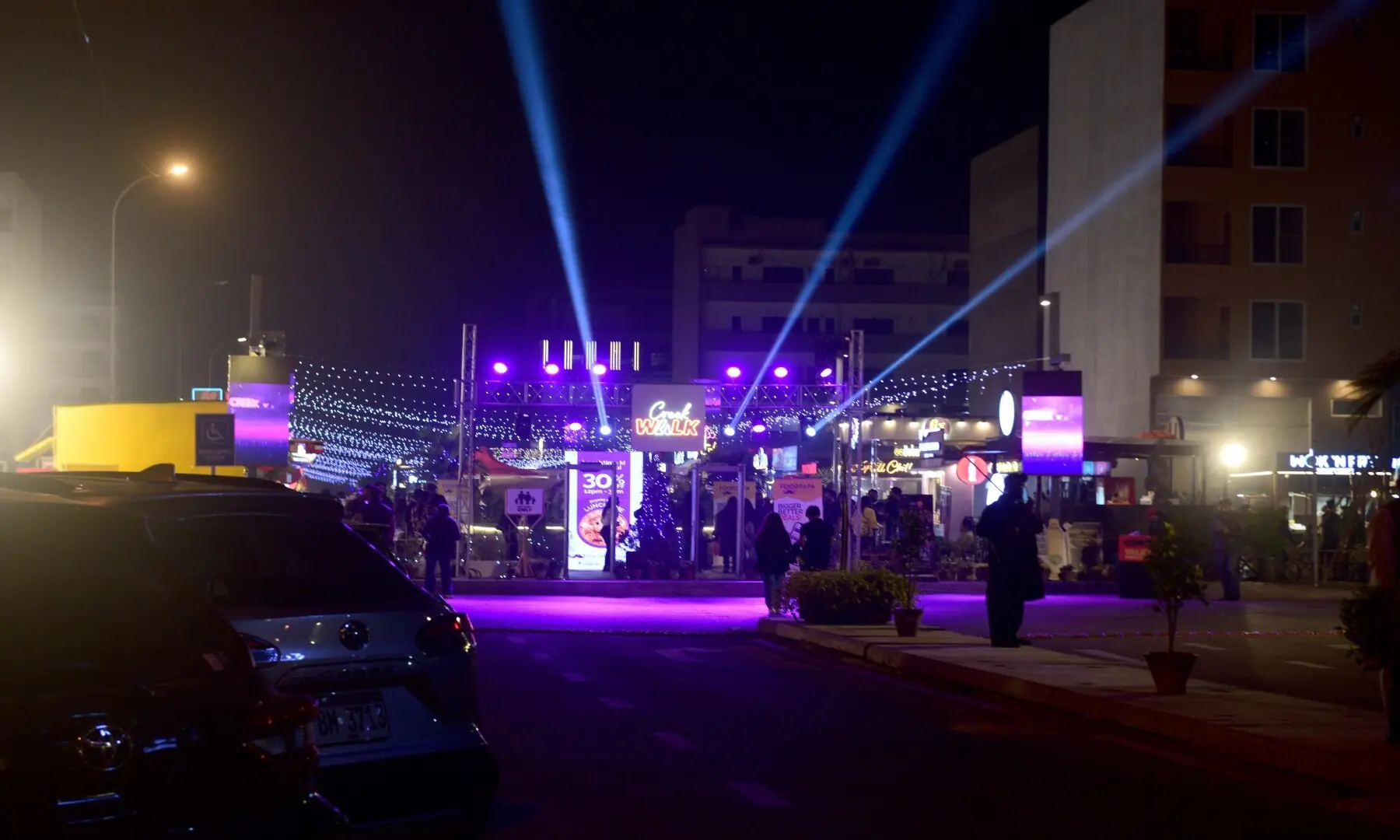 Attractive lights glow from kiosks, welcoming customers to the bustling food street.  &mdash; Tahir Jamal/White Star
