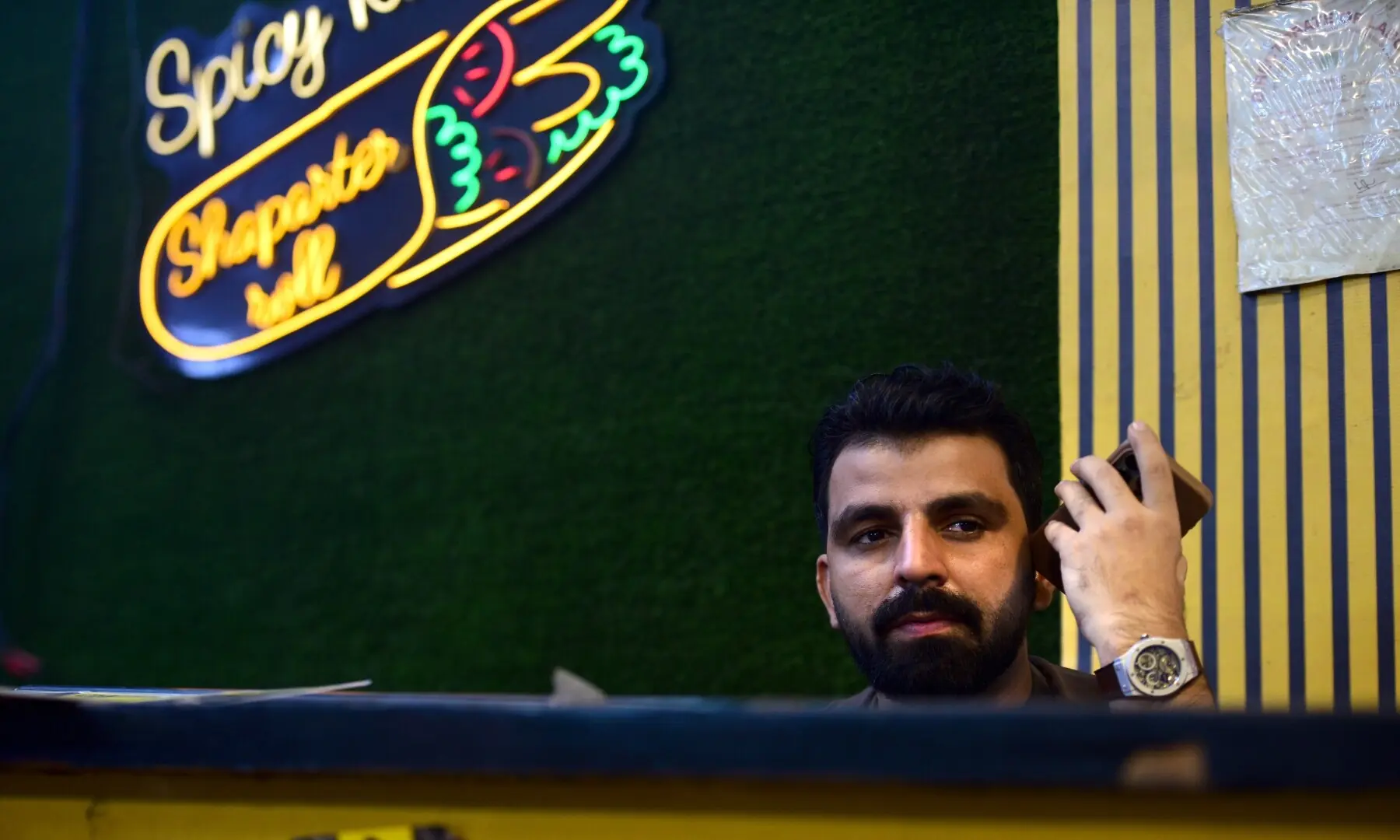 A vendor sits behind the counter of Spicy Khan at Burns Road. &mdash; Tahir Jamal/White Star